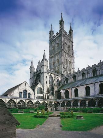 the large cathedral has many windows on it's sides and is surrounded by lush green grass