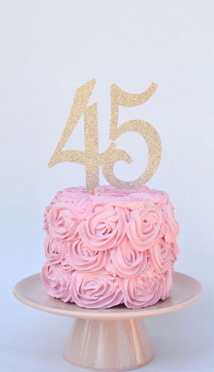 a cake with pink frosting and gold numbers on top