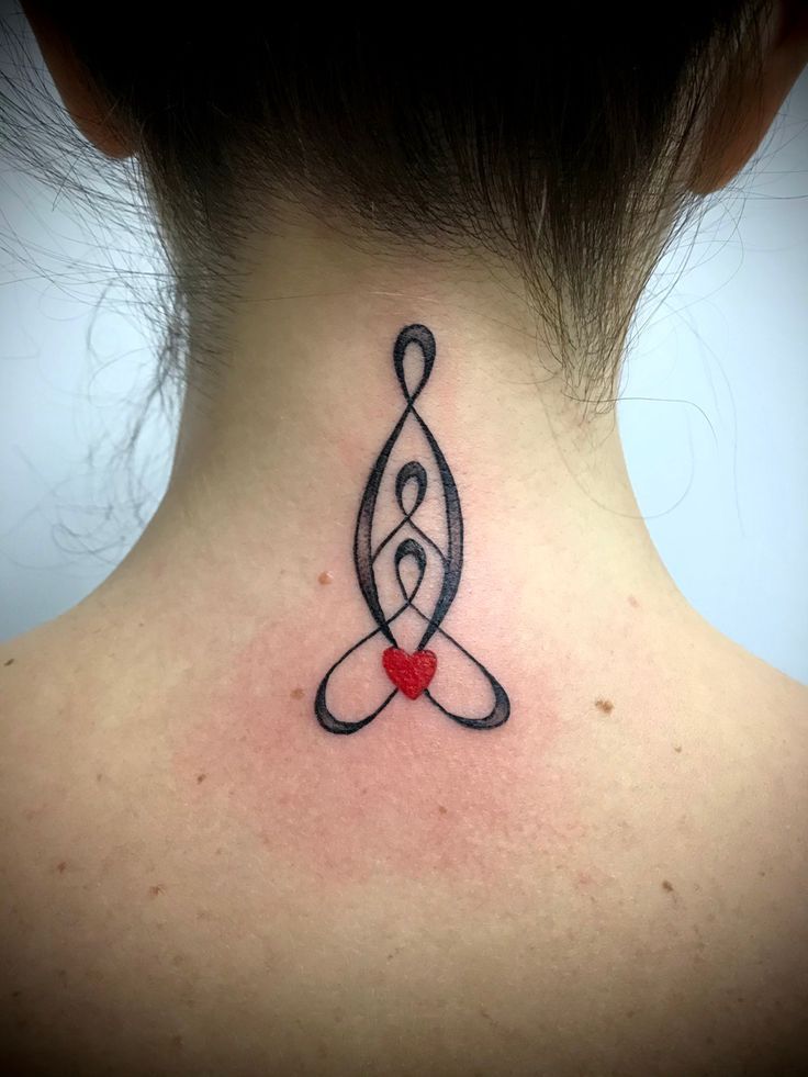 a woman's neck with a tattoo design on the back of her neck, and a red heart in the middle