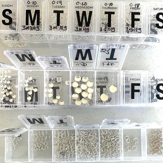 several clear plastic containers filled with different types of screws and studs on display