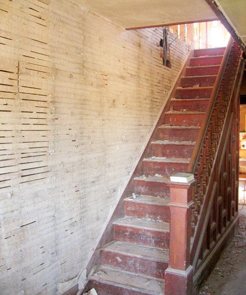 an old staircase in the middle of a rundown building with peeling paint on it