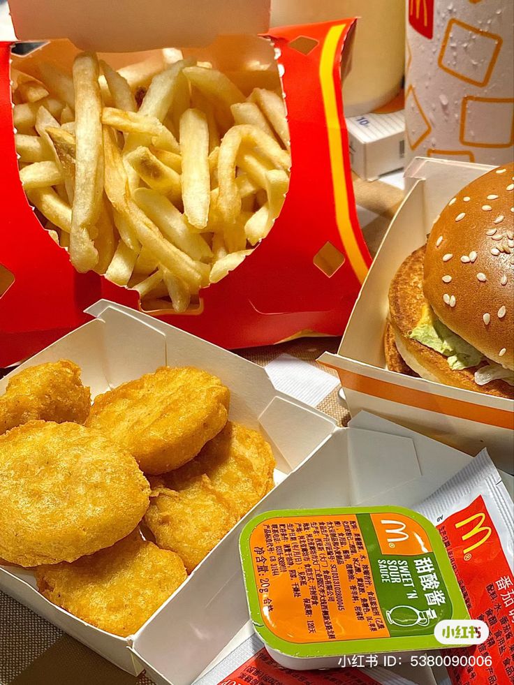 some food is sitting on a table with french fries and a burger in a box