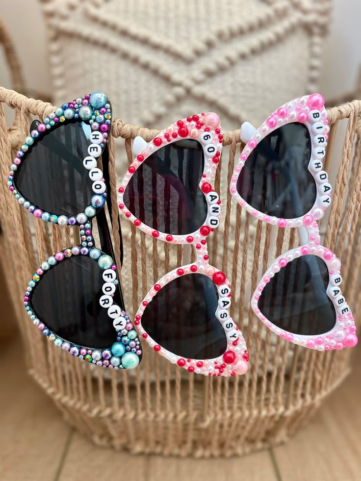 four pairs of sunglasses with beaded frames sitting on top of a wicker basket