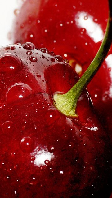 two red cherries with water droplets on them