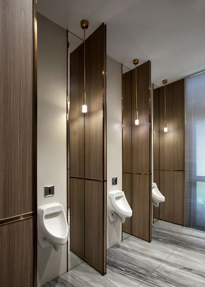 a bathroom with urinals and mirrors in it