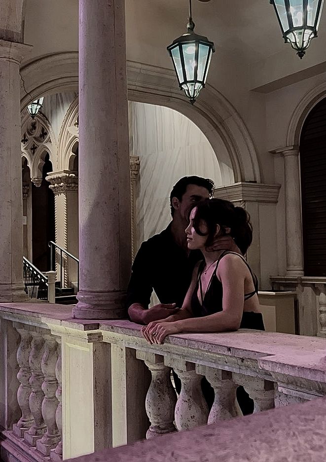 a man and woman are kissing on the balcony