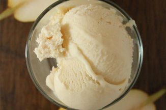 an ice cream sundae in a glass with sliced apples on the table behind it