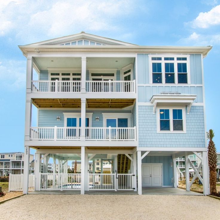 a blue and white two story house on the beach