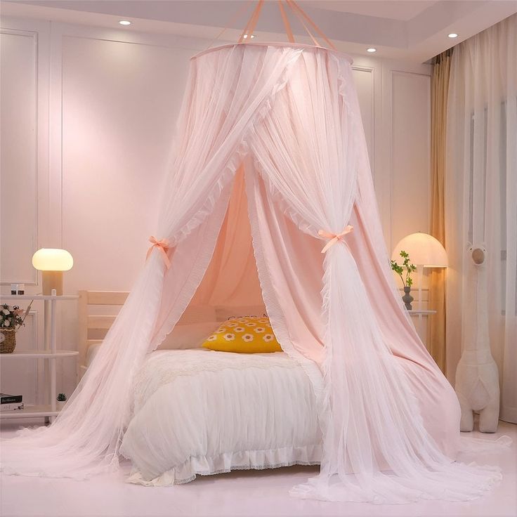 a pink canopy bed in a white bedroom