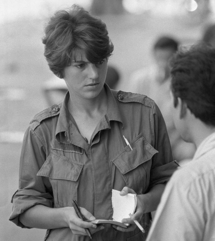 black and white photograph of young boy looking at cell phone while standing next to another person