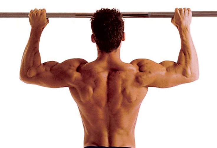 a man with no shirt on is doing pull ups in front of a white background