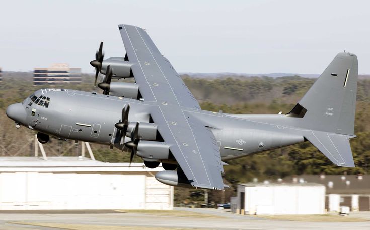 a large air plane taking off from an airport runway with trees in the back ground