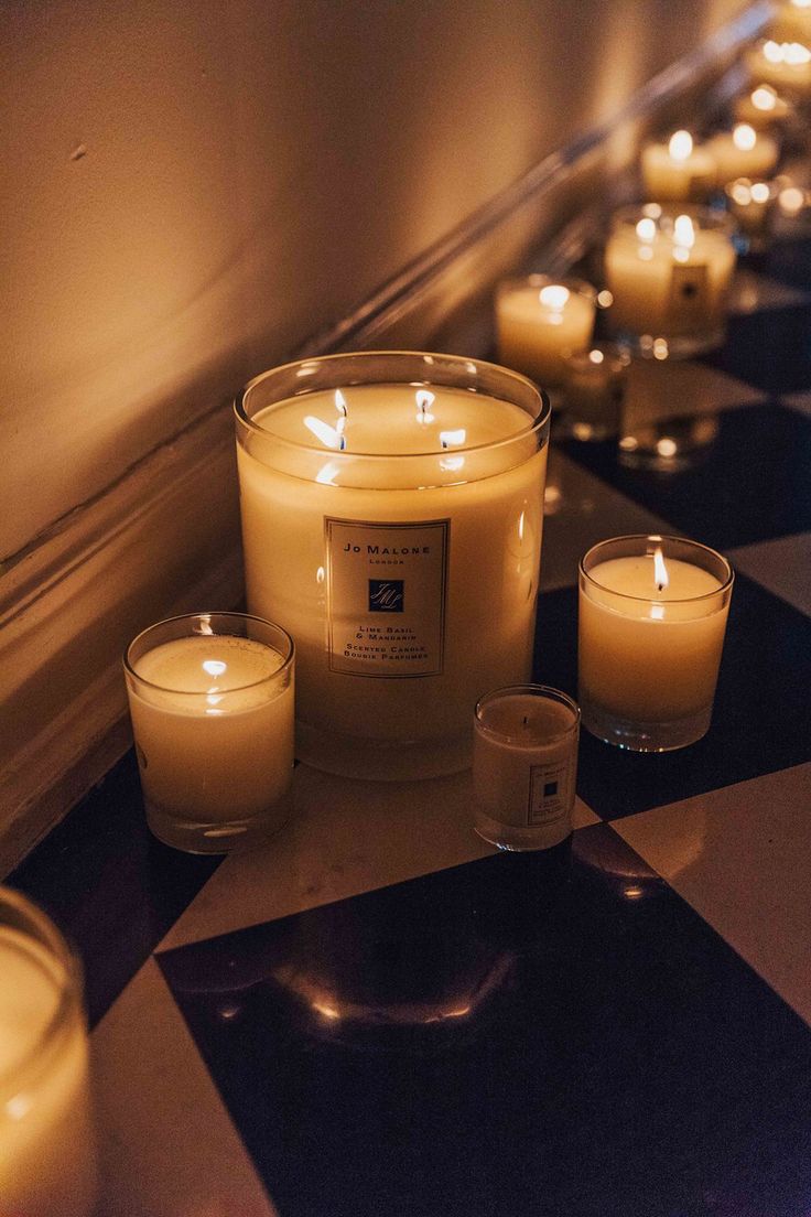 candles lined up on a black and white checkered floor