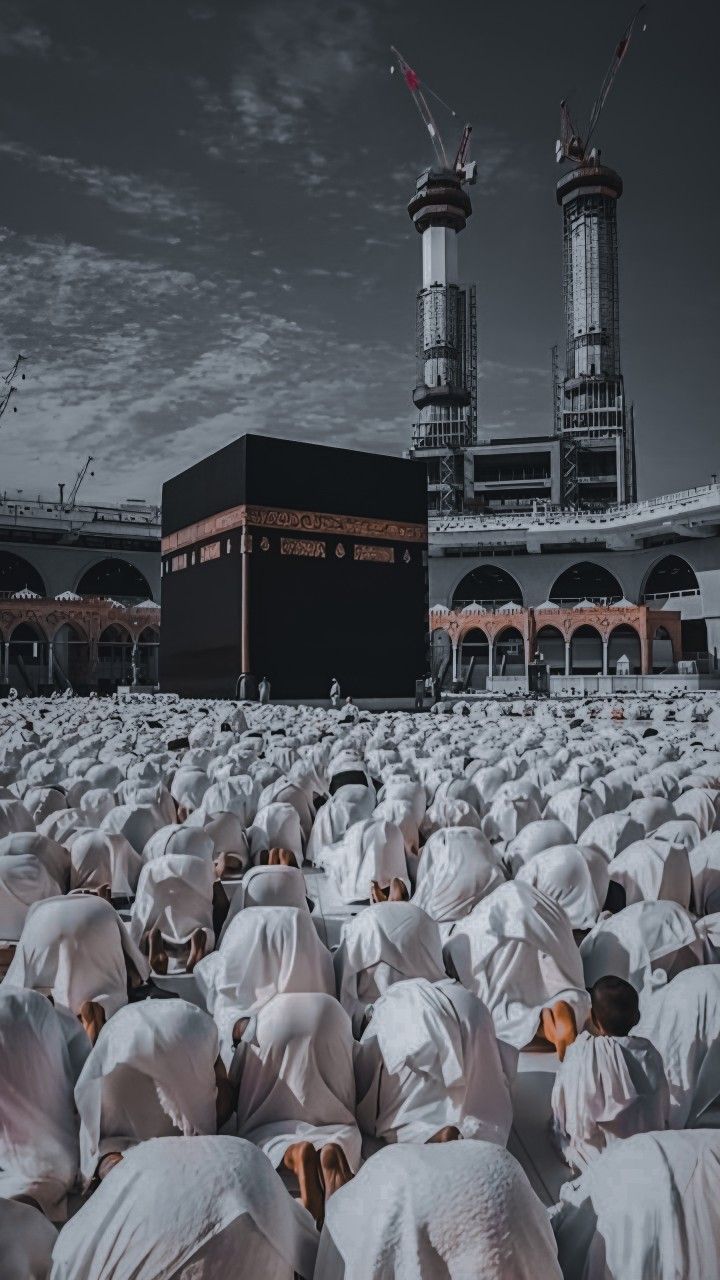 a group of people in white coverings sitting on the ground next to a building