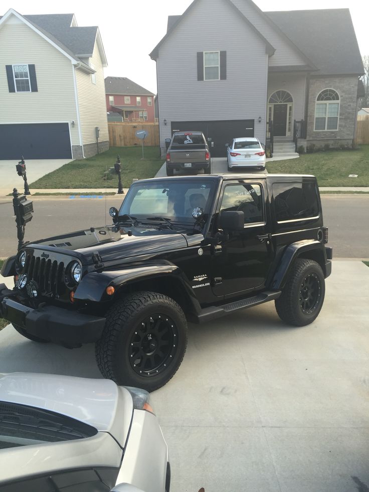 a black jeep parked in front of a house