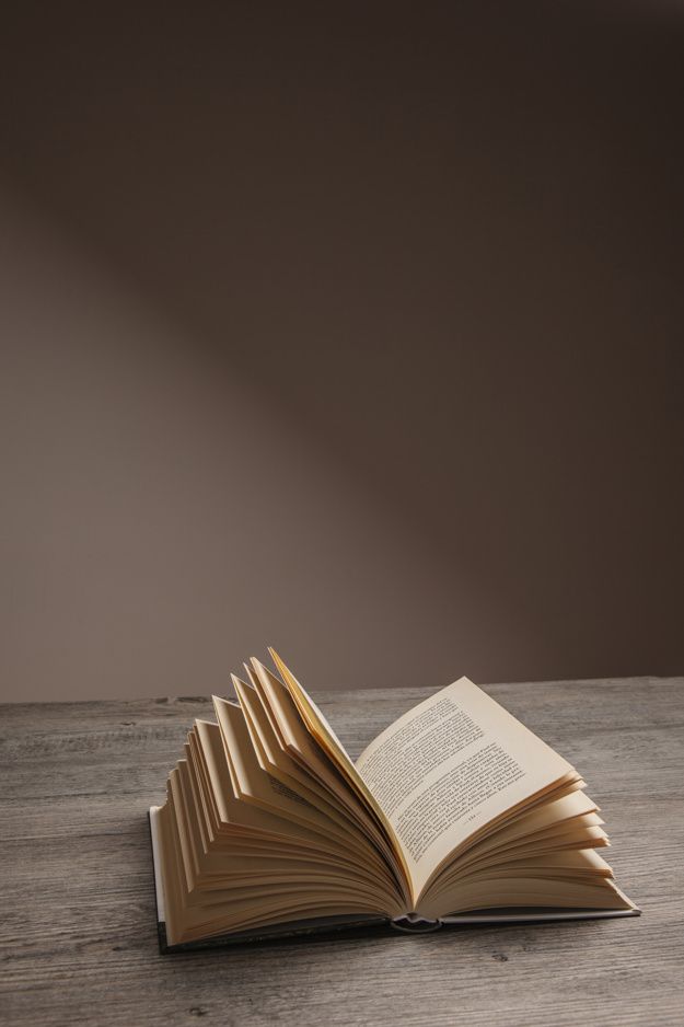 an open book sitting on top of a wooden table