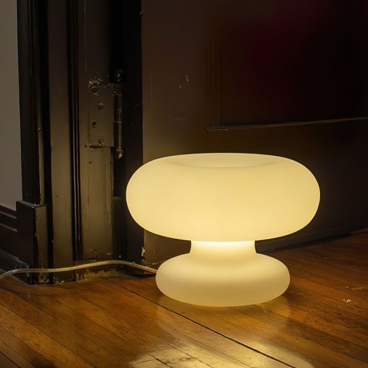 a white light sitting on top of a wooden floor next to a doorway and door