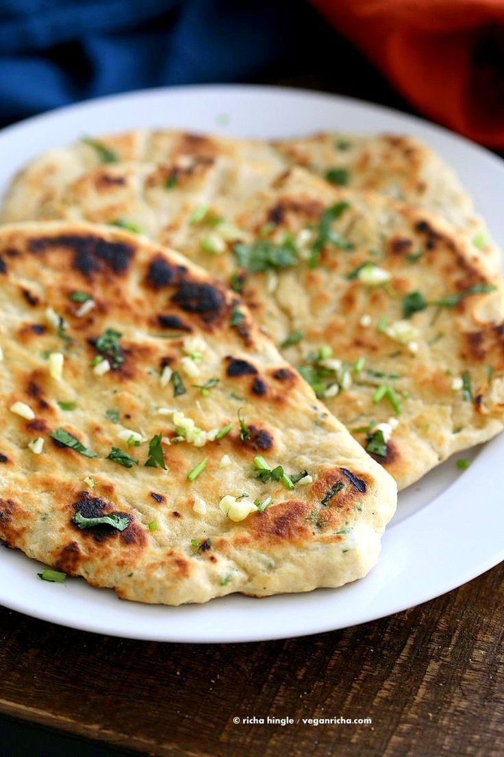 two flat breads are on a white plate