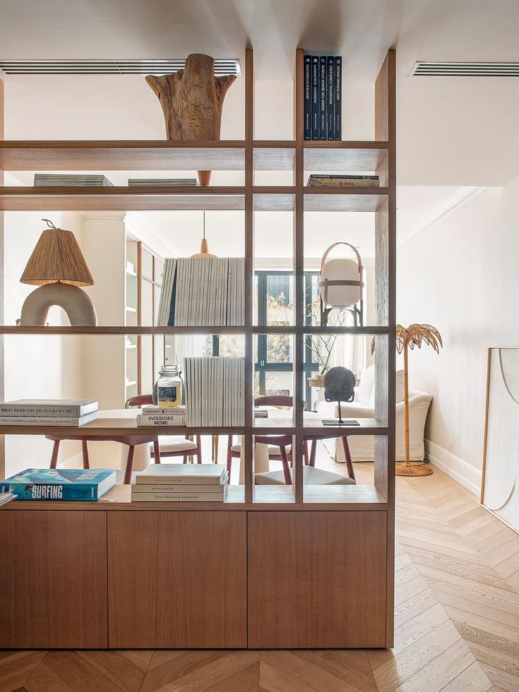 the bookshelf is filled with many different types of books and lamps in this room