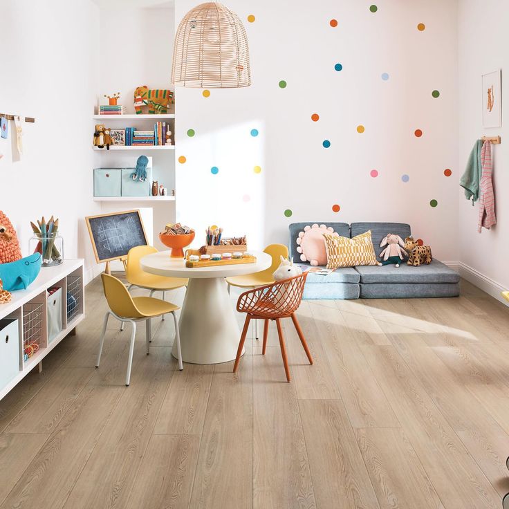 a child's playroom with colorful polka dot wallpaper and wooden flooring