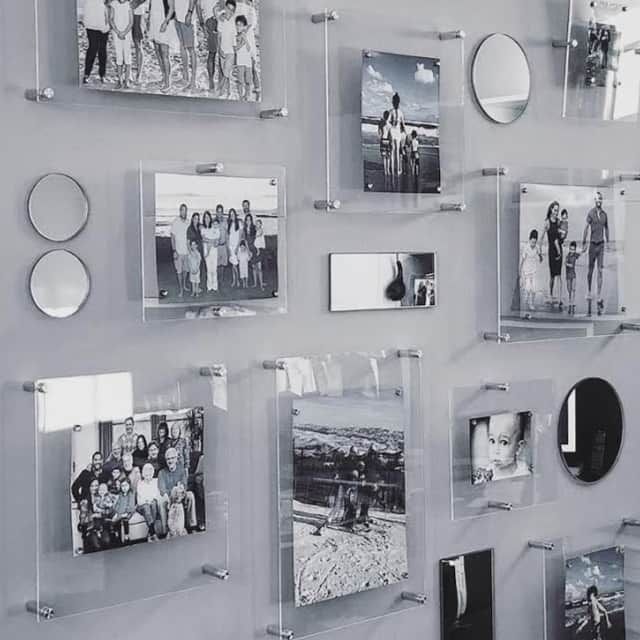 a wall that has some pictures on it with glass frames hanging up against the wall