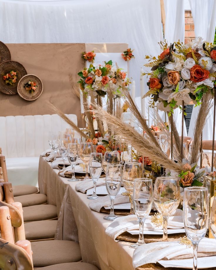 a long table is set with wine glasses and place settings for an elegant wedding reception