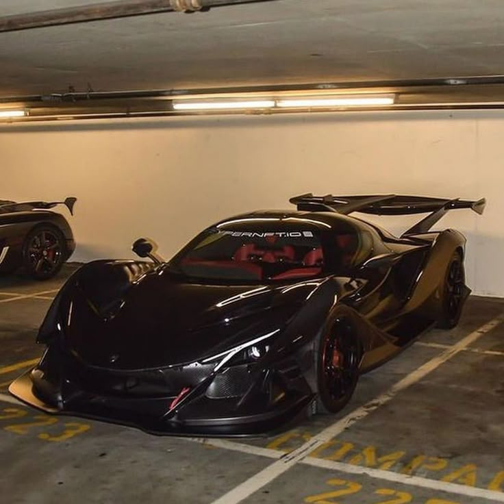 two black sports cars parked in a parking garage