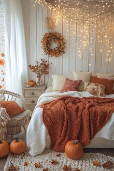 a bedroom decorated for fall with pumpkins and lights