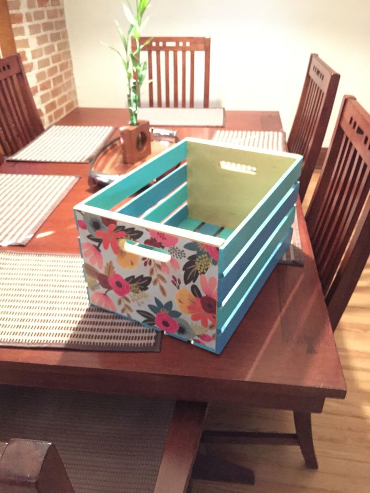 a wooden table topped with a blue box filled with boxes on top of it's sides