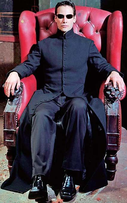 a man sitting in a red chair wearing sunglasses