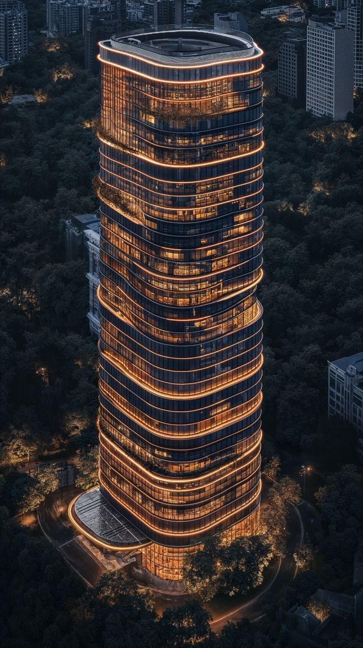 an aerial view of a tall building with many lights on it's sides and trees in the foreground