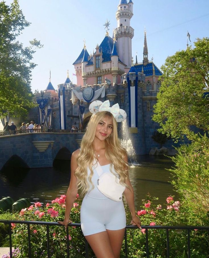 a beautiful young woman standing in front of a castle