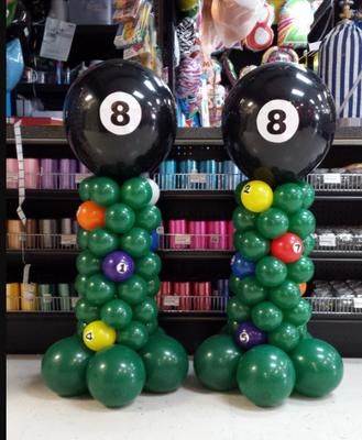 two balloons are made to look like billiards with balls on their heads and numbers