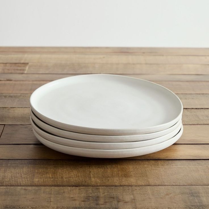 four white plates stacked on top of each other