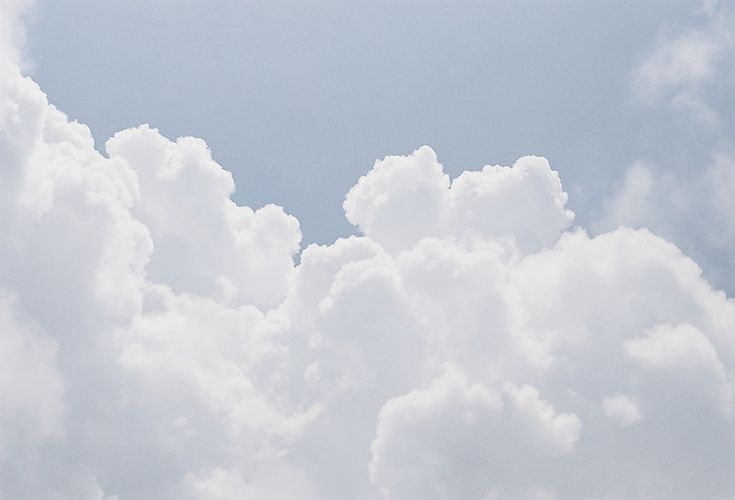 two airplanes flying in the sky with clouds behind them