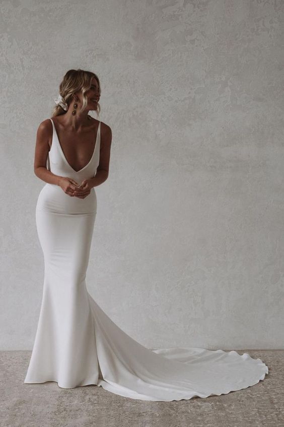 a woman in a white wedding dress posing for the camera