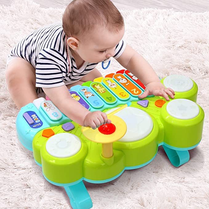 a baby playing with a toy on the beach