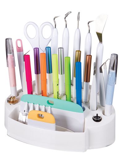 a pen holder with pens, scissors and other office supplies