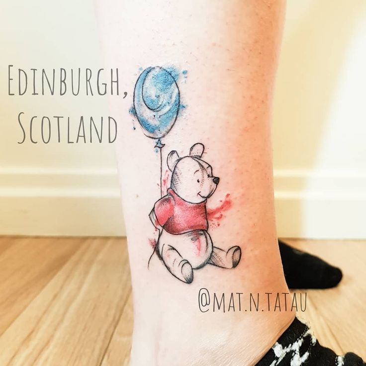 a tattoo on the leg of a woman with a bear holding a balloon