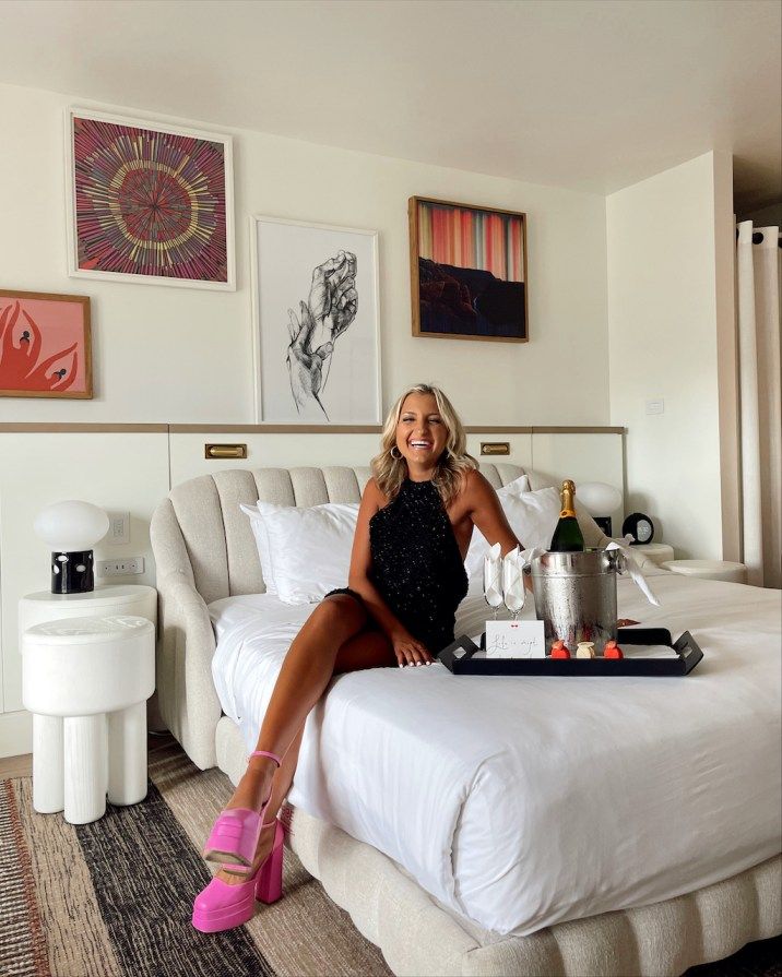 a woman sitting on top of a white bed