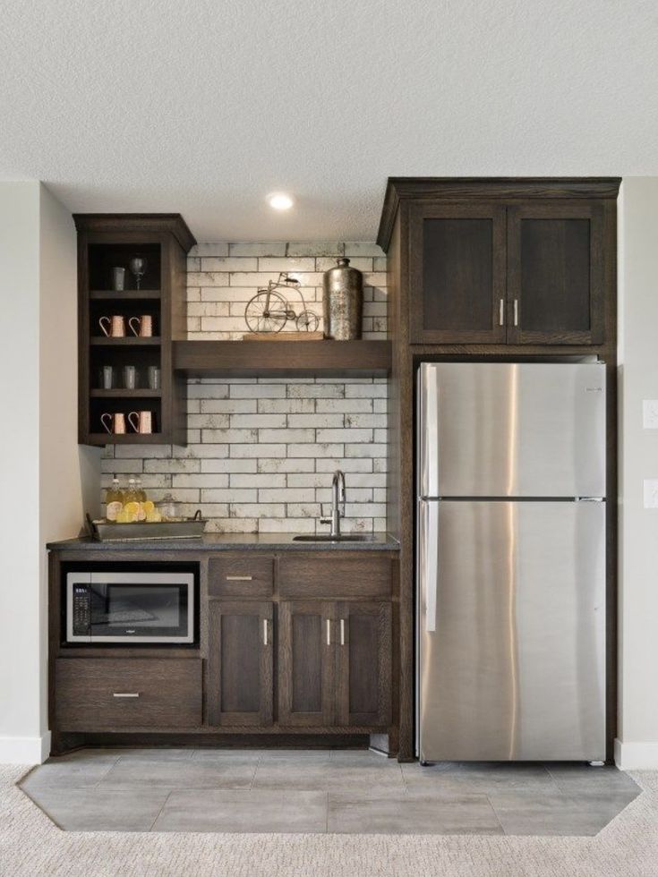 a kitchen with white brick walls and wooden cabinets, stainless steel refrigerator and microwave oven