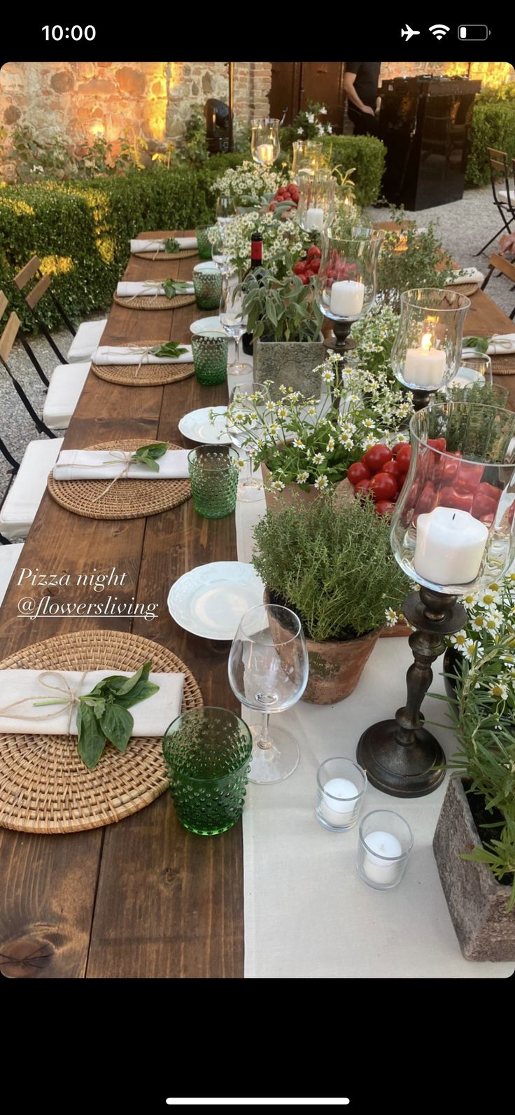 a long table with place settings and flowers on it