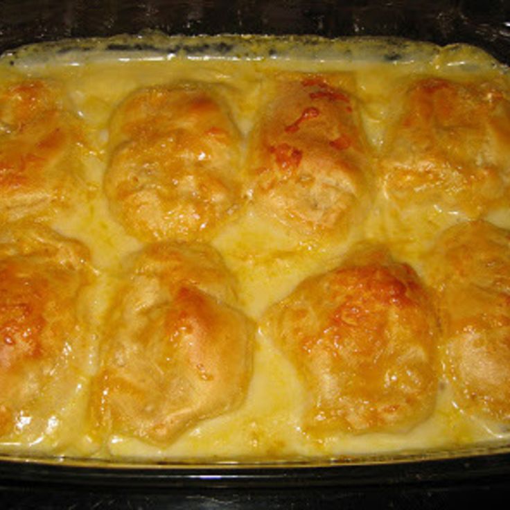 a casserole dish with meatballs and cheese in it sitting on a stove