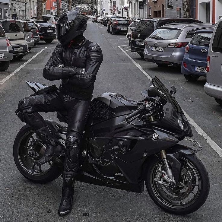 a man dressed in black is sitting on a motorcycle