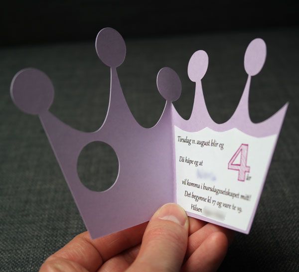 a hand holding up a purple card with a crown on it's side and the number four