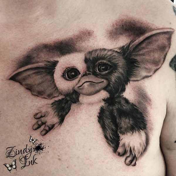 a close up of a person's chest with an owl tattoo on the chest