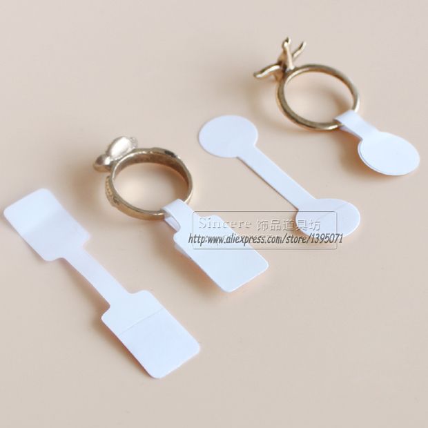 three pieces of white plastic with gold colored metal handles and hooks attached to each other