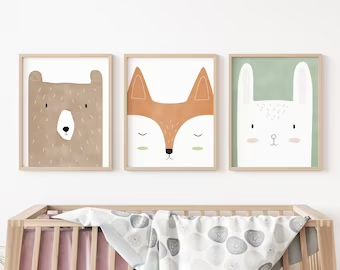 three animal prints hanging on the wall above a crib