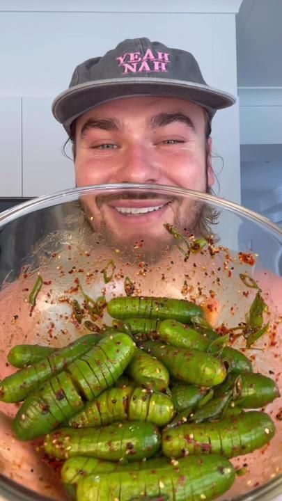 a man holding a bowl full of green beans and seasoning on top of it