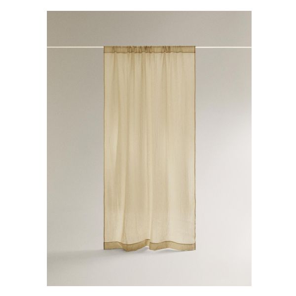 a white curtain hanging on the side of a wall